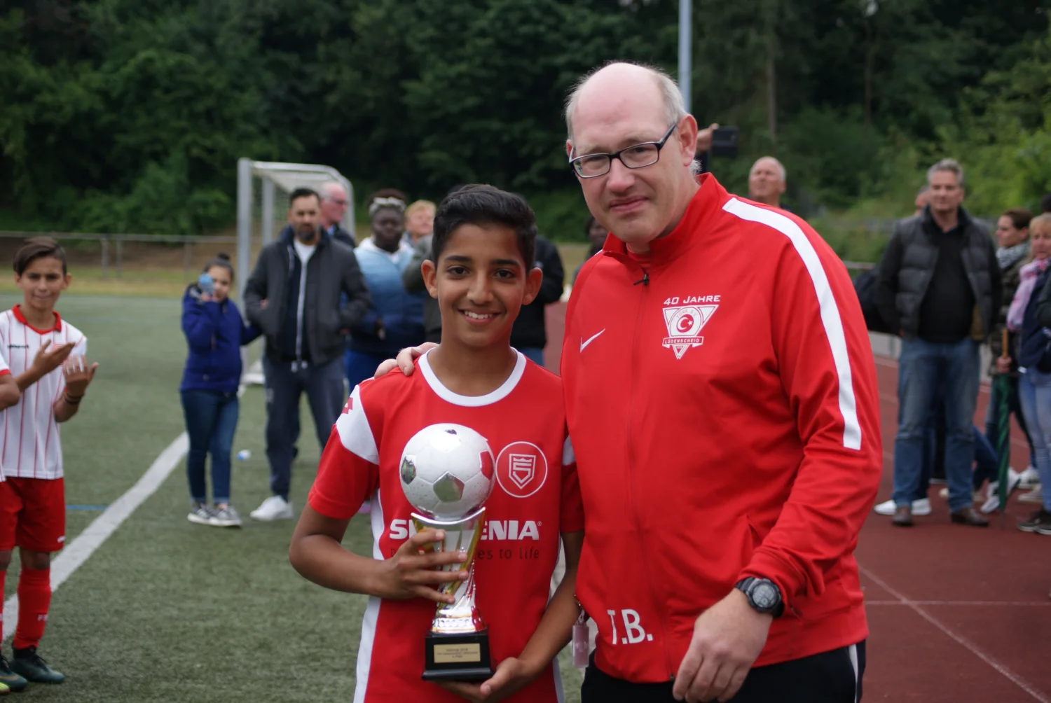 Die Junioren der Sportfreunde Siegen nehmen einen Fußballpokal entgegen